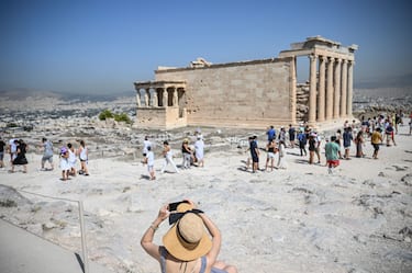 14 July 2023, Greece, Athen: Tourists visit the Parthenon Temple on the Acropolis Hill on this hot day. The Ministry of Culture has decided to close the archaeological site during the hottest hours of the day, from noon to 5 p.m., as Greece is currently experiencing a heat wave. Photo: Angelos Tzortzinis/dpa (Photo by Angelos Tzortzinis/picture alliance via Getty Images)