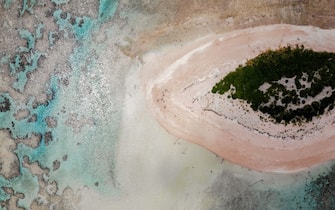 FUNAFUTI, TUVALU - NOVEMBER 26: An aerial view as vegetation regrows on an islet (R) where trees were obliterated by a past storm in the Funafuti atoll on November 26, 2019 in Funafuti, Tuvalu. TheÂ low-lyingÂ South Pacific island nationÂ of about 11,000 people has been classified as â  extremely vulnerableâ   to climate change by theÂ United Nations Development Programme.Â The worldâ  s fourth-smallest country is struggling to cope with climate change related impacts including five millimeter per year sea level rise (above the global average), tidal and wave driven flooding, storm surges, rising temperatures, saltwater intrusion and coastal erosion on its nine coral atolls and islands, the highest of which rises about 15 feet above sea level. In addition, the severity of cyclones and droughts in the Pacific Island region are forecast to increase due to global warming. Some scientists have predicted that Tuvalu could become inundated and uninhabitable in 50 to 100 years or less if sea level rise continues.Â The country is working toward a goal of 100 percent renewable power generation by 2025 in an effort to curb pollution and set an example for larger nations. Tuvalu is also exploring a plan to build an artificial island.  (Photo by Mario Tama/Getty Images)