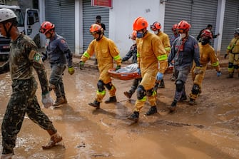 (EDITORS NOTE: Image depicts death.) Firefighters remove a body from debris following a landslide caused by heavy rain and flooding in Barra do Sahy, Sao Paulo state, Brazil, on Friday, Feb. 24, 2023. Heavy rains inundated the Sao Paulo coast during the week of Carnival, causing flooding and landslides that left dozens dead and missing. Photographer: Tuane Fernandes/Bloomberg via Getty Images