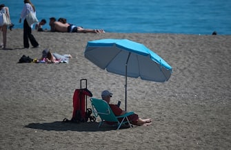MALAGA, SPAIN - 2023/03/12: A bather is seen protecting himself from the sun with an umbrella at Malagueta beach during a hot spring day. The good weather and high temperatures have made the beaches along the Andalusian coast full. The Spanish state meteorology agency warned of an unusual episode of high temperatures over the next few days, with temperatures that could reach over 30 degrees. (Photo by Jesus Merida/SOPA Images/LightRocket via Getty Images)