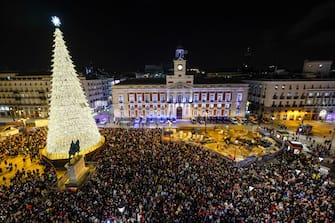 epa10384522 Hundreds of people gather at midnight during the traditional New Year's Eve Chimes on the last day of 2022 and to welcome in 2023, in Madrid, Spain, 31 December 2022.  EPA/Daniel Gonzalez