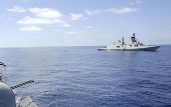 Profughi a bordo della Fregata Euro impegnata nell'operazione Mare Nostrum (sullo sfonfo la fregata Virgilio Fasan), Mar Mediterraneo Meridionale, 30 Agosto 2014. ANSA/GIUSEPPE LAMI