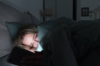 Donna con lo smartphone a letto