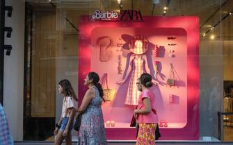 MADRID, SPAIN - 2023/07/22: People walk outside the window of the Zara store on Madrid's Gran Vía street adorned with Barbie motifs for the premiere of a new film about the world-famous doll. (Photo by David Canales/SOPA Images/LightRocket via Getty Images)