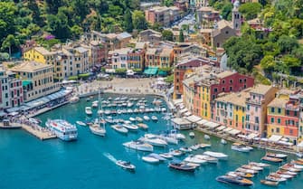 Ships and boats in the small harbor of Portofino, a fishing village and tourist resort on the Italian Riviera coastline, southeast of Genoa city, in Liguria region, northwestern Italy.