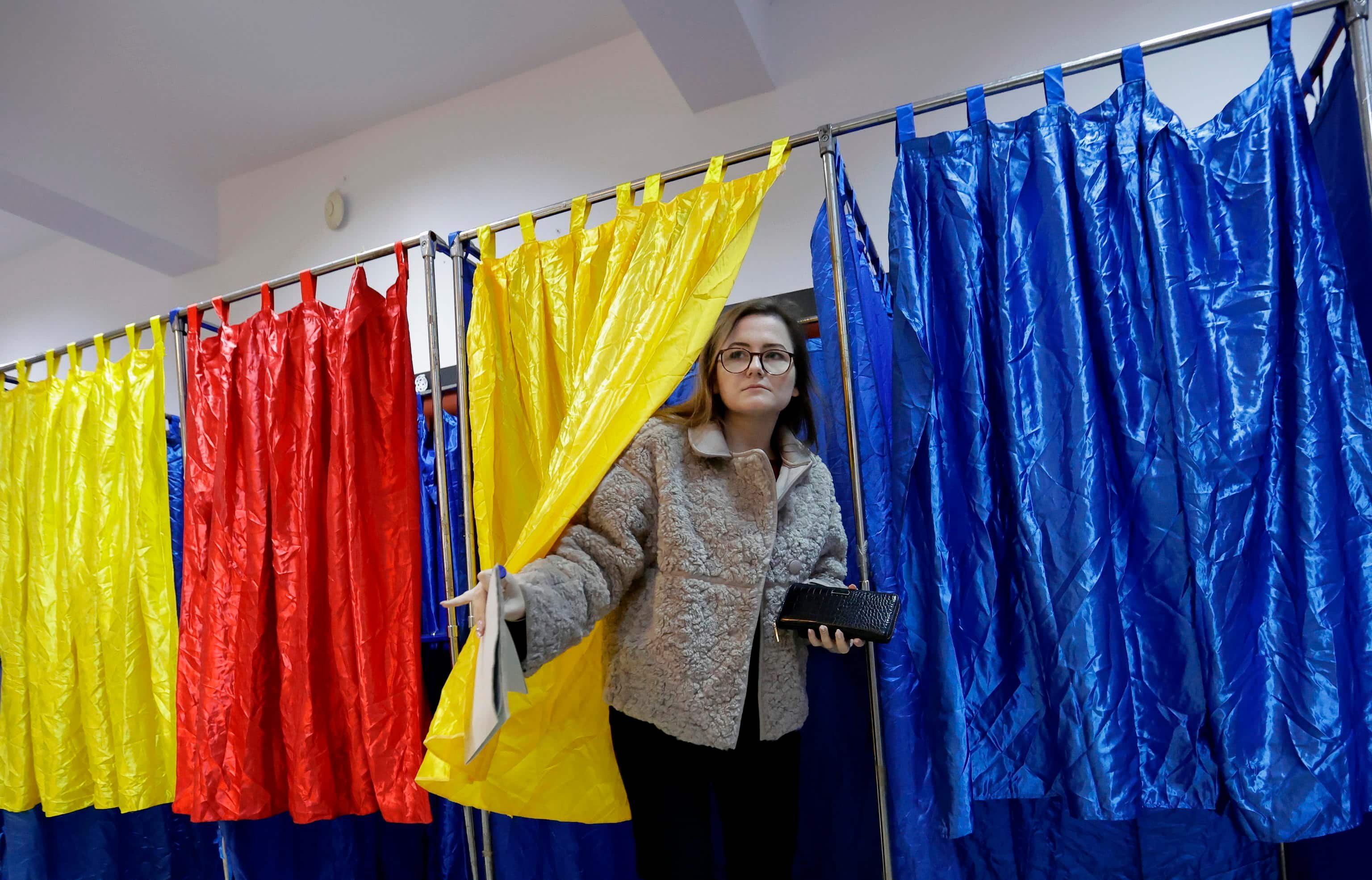 epa11751712 A Romanian woman exits the voting booth after stamping her ballot during the parliamentary elections at Cezar Bolliac Primary School polling station in Bucharest, Romania, 01 December 2024. Approximately 18 million Romanian citizens are expected at the polling stations this weekend for choosing the bicameral parliament members, according to the Permanent Electoral Authority (AEP), of which 989,230 people can express their intention abroad.  EPA/ROBERT GHEMENT