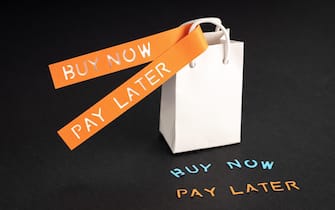 BNPL or Buy Now Pay Later concept. Blank Shopping bag and labels with message on black background