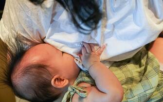 Una mamma allatta il suo neonato