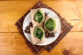 traditional fresh Malaysian nasi lemak packed with banana leaf in wood background