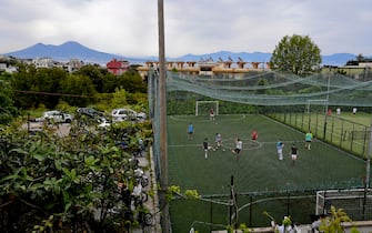 Ragazzi giocano in un campo di calcetto sulla collina di Posillipo a Napoli dove la zona gialla ha consentito l'apertura degli impianti chiusi da mesi, 26  aprile 2021.  ANSA/CIRO FUSCO