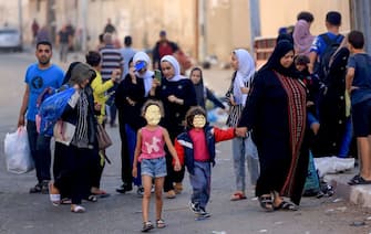 Palestinians carrying their belongings flee to safer areas in Gaza City after Israeli air strikes, on October 13, 2023. Israel has called for the immediate relocation of 1.1 million people in Gaza amid its massive bombardment in retaliation for Hamas's attacks, with the United Nations warning of "devastating" consequences. (Photo by MAHMUD HAMS / AFP) (Photo by MAHMUD HAMS/AFP via Getty Images)