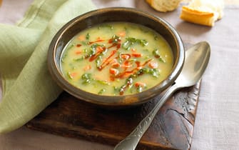 Caldo verde, Portuguese soup in bowl on rustic chopping board