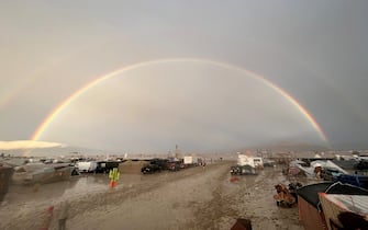 04 September 2023, USA, Black Rock: The undated image shows a rainbow seen over the muddy grounds of the "Burning Man" festival. Tens of thousands of visitors to the desert festival "Burning Man" are stranded on the site in the US state of Nevada after heavy rainfall over the weekend. Photo: David Crane/dpa (Photo by David Crane/picture alliance via Getty Images)