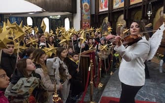 Children holding sticks decorated with stars sing religious songs during a religious service to celebrate the Orthodox Christmas in St. Clement Cathedral in Skopje on January 6, 2024. Eastern Orthodox Christians mark Orthodox Christmas on January 7, according to the old Julian calendar, that pre-dates the Gregorian calendar, which is commonly observed. (Photo by Robert ATANASOVSKI / AFP) (Photo by ROBERT ATANASOVSKI/AFP via Getty Images)