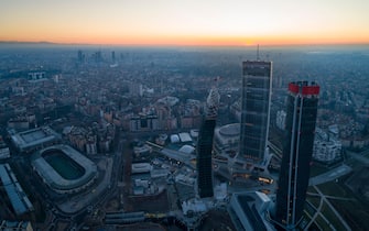 Milan city skyline at sunrise, aerial view. The new 3 skyscrapers (called the straight, the curved and the crooked) of Citylife district at dawn.