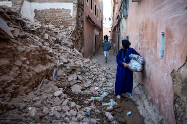 TOPSHOT - A woman looks at the rubble of a building in the earthquake-damaged old city in Marrakesh on September 9, 2023. A powerful earthquake that shook Morocco late September 8 killed more than 600 people, interior ministry figures showed, sending terrified residents fleeing their homes in the middle of the night. (Photo by FADEL SENNA / AFP) (Photo by FADEL SENNA/AFP via Getty Images)