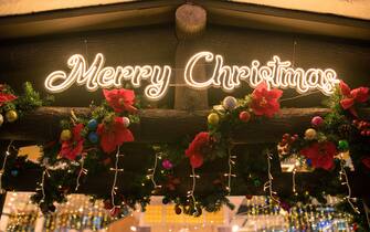 Merry Christmas alphabet with LED neon light on wall with Christmas ornament decoration.