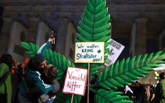 epa11254019 Participants kiss in front of a giant hemp leaf at the Brandenburg Gate on the occasion of a so called 'Smoke-In' event in Berlin, Germany, 01 April 2024. Activists and supporters welcomed a new status of law, regarding the use of cannabis, in Germany. The German Federal Council 'Bundesrat' on 22 March approved a law decriminalizing the recreational usage of cannabis in Germany for adults age 18 and over. Starting 01 April 2024 it will be legal for adults in Germany to possess up to 50 grams of dried cannabis at home and up to 25 grams in public for personal use. The law allows growth and distribution only in cultivation associations also called Cannabis Social Clubs and comes into force on 01 July 2024. People can purchase cannabis for recreational use if they are members of those specific clubs but cannot consume it in the premises.  EPA/CLEMENS BILAN