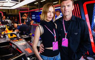 NORTHAMPTON, ENGLAND - JULY 09: Sam Worthington and Lara Worthington pose for a photo in the Red Bull Racing garage prior to the F1 Grand Prix of Great Britain at Silverstone Circuit on July 09, 2023 in Northampton, England. (Photo by Mark Thompson/Getty Images)