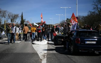 Protesters block the street in front of the Saint Louis de Gonzague school during a demonstration called by several unions to protest against the pension reform, in a context of the start of the baccalaureate exams, in Perpignan, southwestern France, on March 20, 2023. - French Prime Minister Elisabeth Borne on March 20, 2023,  faces two motions of no confidence in the National Assembly lower house, after forcing through an unpopular pension reform last week without a vote. (Photo by Valentine CHAPUIS / AFP)