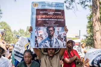 TOPSHOT - Health workers hold placards during a demonstration led by the South African Medical Association Trade Union (SAMATU) for unemployed health workers at the Union Building in Pretoria on February 26, 2024. (Photo by EMMANUEL CROSET / AFP) (Photo by EMMANUEL CROSET/AFP via Getty Images)