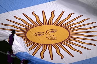 Volunteers carry an Argentina flag before the start of the Qatar 2022 World Cup Group C football match between Poland and Argentina at Stadium 974 in Doha on November 30, 2022. (Photo by Kirill KUDRYAVTSEV / AFP) (Photo by KIRILL KUDRYAVTSEV/AFP via Getty Images)