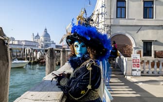 A woman is dressed for the Venice Carnival and is overlooking the Grand Canal in Venice, Italy, on January 30, 2024. (Photo by Andrea Mancini/NurPhoto via Getty Images)