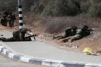 epa10911381 Israeli soldiers take position next to Kfar Aza kibbutz near the border with Gaza, 10 October 2023. More than 900 people have been killed, around 150 were taken as hostages, and 1,500 others injured, according to Israel Defence Forces (IDF), after the Islamist movement Hamas launched an attack against Israel on 07 October. More than 3,000 people, including 1,500 militants from Hamas, have been killed and thousands injured in Gaza and Israel since 07 October, according to Israeli military sources and Palestinian officials.  EPA/ATEF SAFADI