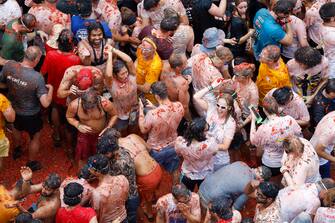 epa10828458 People participate in La Tomatina, a traditional and world-wide known tomato fight festival, in Bunol, Valencia province, eastern Spain, 30 August 2023. As every year on the last Wednesday of August, thousands of people visit the small village of Bunol to attend the Tomatina, a battle in which tons of ripe tomatoes are used to throw at each other.  EPA/MIGUEL ANGEL POLO