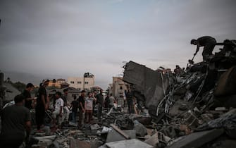 DEIR AL-BALAH, GAZA - OCTOBER 31: Civilians conduct a search and rescue operation under the debris of destroyed building following the Israeli attacks on the Nuseirat Camp in Deir al Balah, Gaza on October 31, 2023. (Photo by Mustafa Hassona/Anadolu via Getty Images)