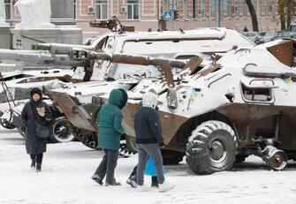 epa10997591 People walk past snow covered, destroyed Russian machinery displayed in Kyiv, Ukraine, 27 November 2023 amid the Russian invasion. An active southern cyclone brought heavy rainfall and strong winds to most regions of Ukraine, the Ukrainian Hydrometeorological Center reports.  EPA/SERGEY DOLZHENKO