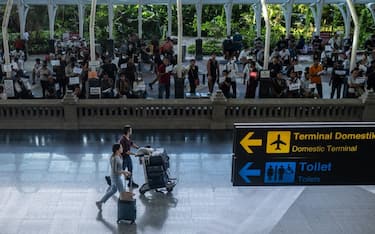 DENPASAR, BALI, INDONESIA - DECEMBER 7: Foreign tourists push a trolly which contain of luggages as they arrive at the International arrival of Ngurah Rai airport on December 7, 2022 in Denpasar, Bali, Indonesia. Indonesia's parliament voted to pass a law that bans extramarital sex on Tuesday, in a move that critics quoted in local media have said will severely impact the tourism industry. Regions like Bali rely heavily on an influx of foreign tourists to keep their economies afloat, and the new law has raised concerns just as international arrivals start to pick up again post-pandemic.  (Photo by Agung Parameswara/Getty Images)