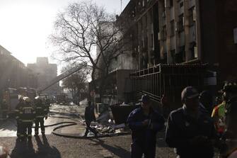 South African firefighters and South African Police Service officers work at the sceen of a fire in Johannesburg on August 31, 2023. At least 20 people have died and more than 40 were injured in a fire that engulfed a five-storey building in central Johannesburg on Thursday, the South African city's emergency services said. (Photo by Michele Spatari / AFP) (Photo by MICHELE SPATARI/AFP via Getty Images)