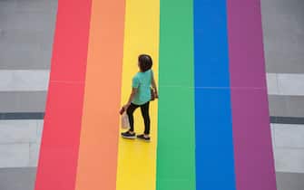 A woman walks on a huge rainbow flag placed at the entrance of Samyan Mitrtown shopping mall.
Samyan Mitrtown, a mixed-use shopping, office, residential and leisure development celebrated the LGBTQ Pride Month 2021 by decorated the floor at the entrance and the tunnel of the mall with the huge and long rainbow flag. "Samyan Mitr Proud 100% Love" in Bangkok, Thailand. (Photo by Peerapon Boonyakiat / SOPA Images/Sipa USA)