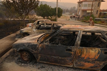 epa10813184 A man points at burnt cars during a wildfire, in Palagia village,  Alexandroupolis, Thrace, northern Greece, 22 August 2023. The Alexandroupolis General Hospital was evacuated as a large fire was approaching the northern Greek city.Patients were evacuated with ambulances provided by the Health Ministry and the help of a large police force stationed in the region for the purpose.Two separate messages of the 112 emergency service had been issued to residents of Alexandroupolis, a major port and energy hub, alerting them to heavy smoke from fires in the region and ordering them to stay indoors with shut doors and windows.After 02.00 in the morning, the villages of Dikela, Makri, Nea Chili, Elaionas, Ag. Giorgis, Plaka, Enato and Pefki were also evacuated.  EPA/DIMITRIS ALEXOUDIS
