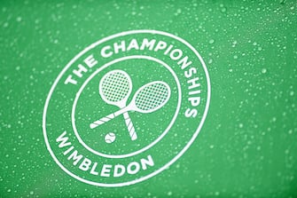 epa10036427 The Wimbledon logo on an umbrella is covered in rain as games are temporarily suspended due to rain on the first day at the Wimbledon Championships, in Wimbledon, Britain, 27 June 2022.  EPA/NEIL HALL   EDITORIAL USE ONLY