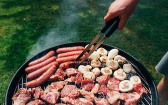 Grilled meat, sausages and mushrooms. B-B-Q. Food in nature. Cooking food on the grill. Picnic. Holiday in nature.