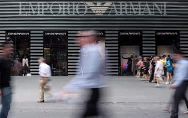 epa02876781 Shoppers walk past an Armani store on Orchard Road in Singapore on 22 August 2011. Asian stocks continue to fall with the regional index declining for a fourth straight week, as the global stock rout continued amid signs the world economy is slowing and Europe's debt crisis may damage the banking system.  EPA/STEPHEN MORRISON