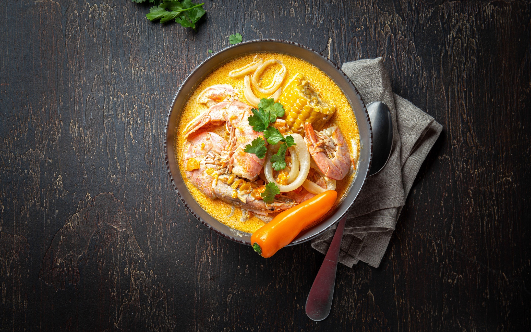 Peruvian seafood soup Chupe de Camarones in gray bowl, top view.