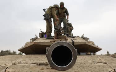 TOPSHOT - Israeli army soldiers are positioned with their Merkava tanks near the border with the Gaza Strip in southern Israel on October 9, 2023. Israel relentlessly pounded the Gaza Strip early October 9 as fighting raged with Hamas around the Gaza Strip and the death toll from the war against the Palestinian militants surged above 1,100. (Photo by JACK GUEZ / AFP) (Photo by JACK GUEZ/AFP via Getty Images)