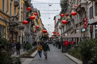MILAN, ITALY - FEBRUARY 08: People stroll past some red Chinese lanterns in the Paolo Sarpi district (Milan's Chinatown) on February 08, 2024 in Milan, Italy. The Chinese community of Milan - the largest in Italy, counting over 40.000 people mainly natives of the coastal province of Zhejiang - is preparing to celebrate the 'Chunjie', also known as Chinese Lunar New Year, marking the beginning of the Year of theÂ Dragon. (Photo by Emanuele Cremaschi/Getty Images)