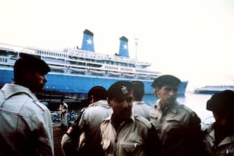 Security forces stand in front of Italian cruise ship Achille Lauro, docked on October 10, 1985 in Port Said harbor after Egyptian authorities stopped it from sailing to the Israeli port of Ashdod. Achille Lauro was seized by a commando of the Palestine Liberation Front (PLF) of Abu Abbas who organized the hijacking off the Egyptian coast on October 07, 1985 taking its 450 passengers hostages. A handicapped Jewish-American passenger, Leon Klinghoffer, was killed by commando chief Majid al-Molki and thrown overboard. The Achille Lauro sank in the Indian Ocean after a three-day fire in December 1994. (Photo credit should read MIKE NELSON/AFP via Getty Images)