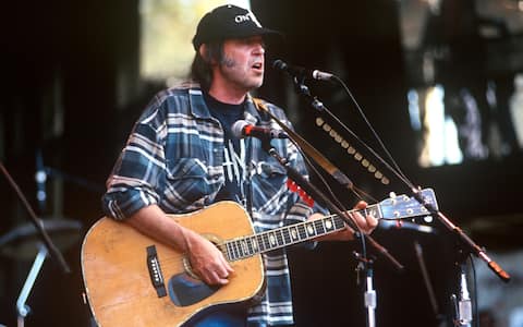 Neil Young performs during Neil Young's Annual Bridge School benefit at Shoreline Amphitheatre on October 18, 1997 in Mountain View, California. (Photo by Tim Mosenfelder/Getty Images)