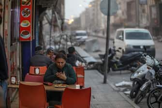ISKENDERUN, TURKEY - FEBRUARY 28: People sits and eat fast food near the destroyed building on February 28, 2023 in Iskenderun , Turkey. A 7.8-magnitude earthquake hit near Gaziantep, Turkey, in the early hours of Monday February 6, followed by another 7.5-magnitude tremor just after midday. The quakes caused widespread destruction in southern Turkey and northern Syria and were felt in nearby countries. (Photo by Aziz Karimov/Getty Images)