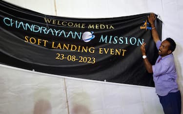 epa10815349 Indian labourers hang a poster during the soft landing of the 'Chandrayaan-3 Mission' event at ISRO Telemetry, Tracking and Command Network (ISTRAC) in Bangalore, India, 23 August 2023. Indian Space Research Organisation (ISRO) space exploration Chandrayaan-3 Mission is expected to land on the moon on 23 August at approximately 18:04 (IST).  EPA/JAGADEESH NV