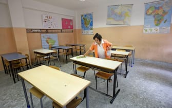 Una bidella pulisce un'aula il primo giorno di scuola al liceo Newton di Roma, oggi 12 settbre 2011 a Roma.
ANSA/ALESSANDRO DI MEO