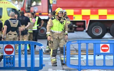 Firefighters are pictured in the street where at least thirteen people were killed in a fire at a nightclub in Murcia, on October 1, 2023. At least 13 people were killed in a fire in a Spanish nightclub today morning, authorities said, with fears the toll could still rise as rescue workers sift through the debris. The fire appears to have broken out in a building housing the "Teatre" and "Fonda Milagros" clubs in the city of Murcia in southeastern Spain in the early morning hours. (Photo by JOSE JORDAN / AFP) (Photo by JOSE JORDAN/AFP via Getty Images)