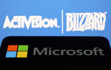 Microsoft logo displayed on a phone screen and Activision Blizzard logo displayed on a screen in the background are seen in this illustration photo taken in Krakow, Poland on July 17, 2023. (Photo by Jakub Porzycki/NurPhoto via Getty Images)