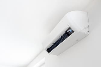 Air conditioner on white wall in interior