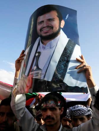 epa10929448 A Yemeni holds up a picture depicting the top Houthi leader, Abdul-Malik al-Houthi, during a rally in solidarity with the Palestinian people, in Sana'a, Yemen, 20 October 2023. Thousands of Israelis and Palestinians have died since the militant group Hamas launched an unprecedented attack on Israel from the Gaza Strip on 07 October 2023, leading to Israeli retaliation strikes on the Palestinian enclave.  EPA/YAHYA ARHAB